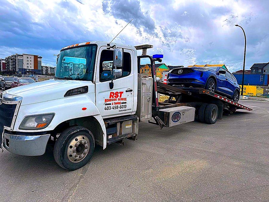 RST flatbed tow truck loading a vehicle in Calgary
