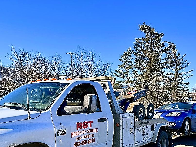 RST tow truck towing a vehicle on a local Calgary street